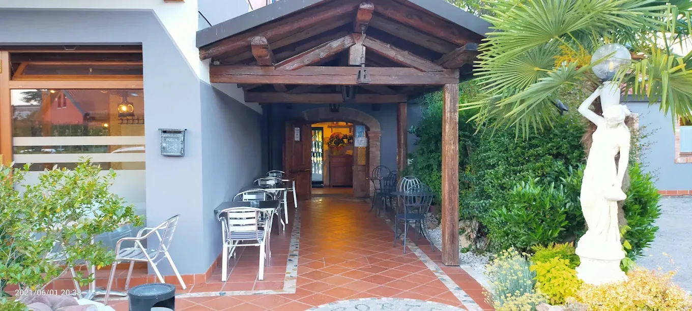 L’ingresso con il portico in legno e i tavoli all’aperto