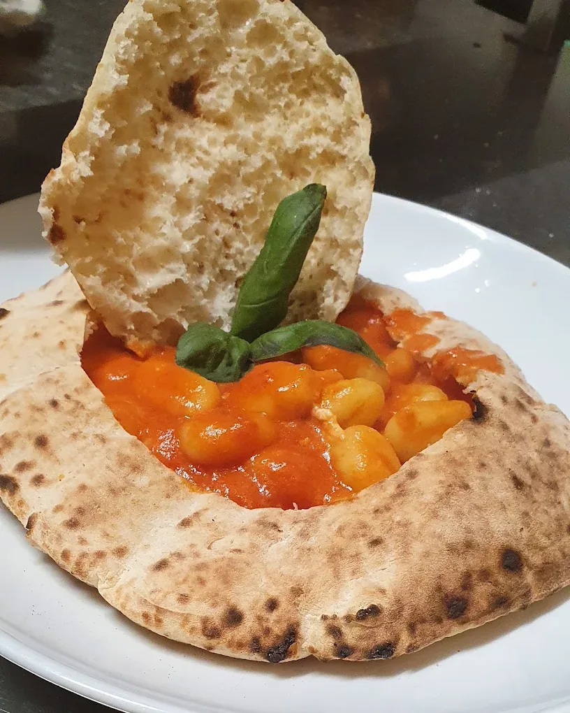 Gnocchi al pomodoro serviti in un guscio di pizza